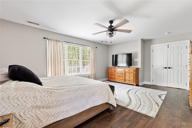bedroom featuring baseboards, ceiling fan, visible vents, and wood finished floors