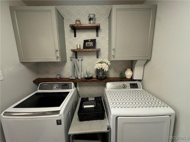 washroom with washing machine and dryer and cabinet space