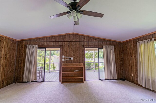 10 Mahon, Ruther Glen, VA 22546 - unfurnished living room featuring carpet flooring, wood walls, plenty of natural light, a ceiling fan, and lofted ceiling
