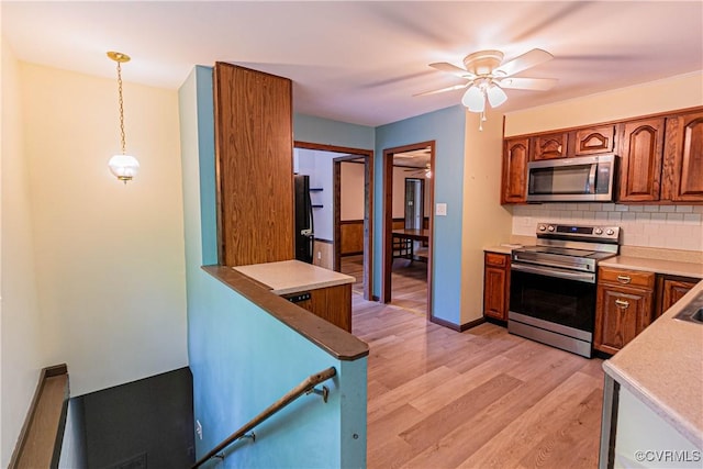 10 Mahon, Ruther Glen, VA 22546 - kitchen featuring stainless steel appliances, backsplash, light wood-style floors, brown cabinets, and ceiling fan