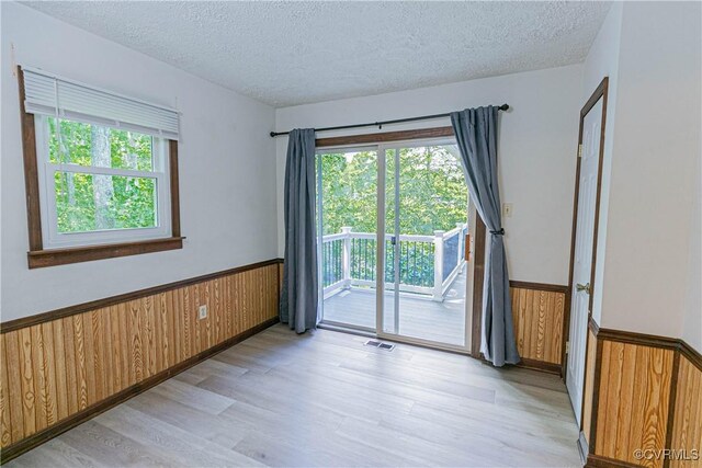 10 Mahon, Ruther Glen, VA 22546 - spare room with a wainscoted wall, a textured ceiling, light wood finished floors, and wooden walls