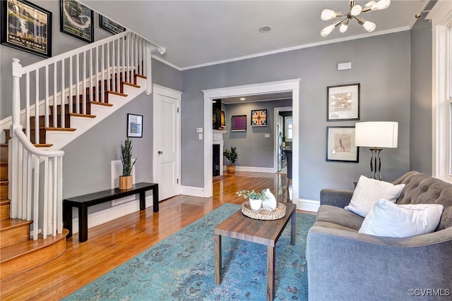 living room featuring stairway, a chandelier, wood finished floors, and baseboards