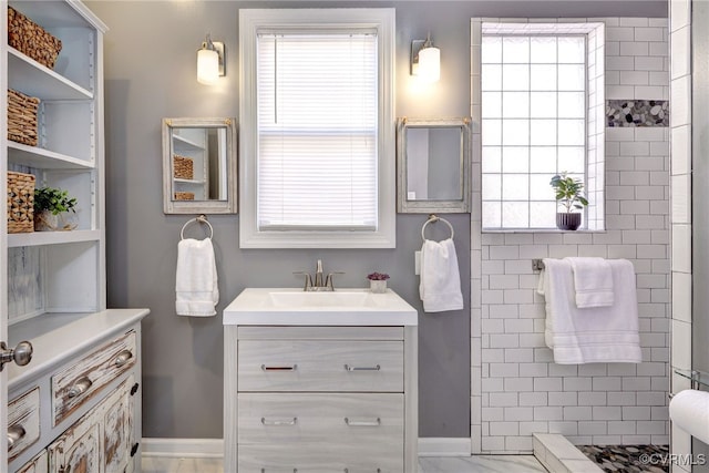bathroom featuring a tile shower, vanity, and plenty of natural light