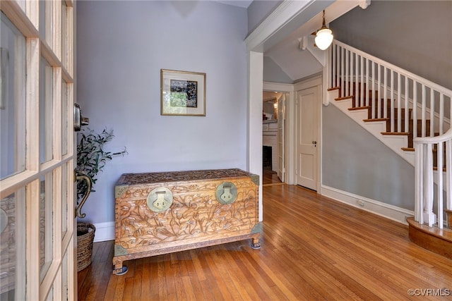 foyer entrance with wood-type flooring, stairs, and baseboards