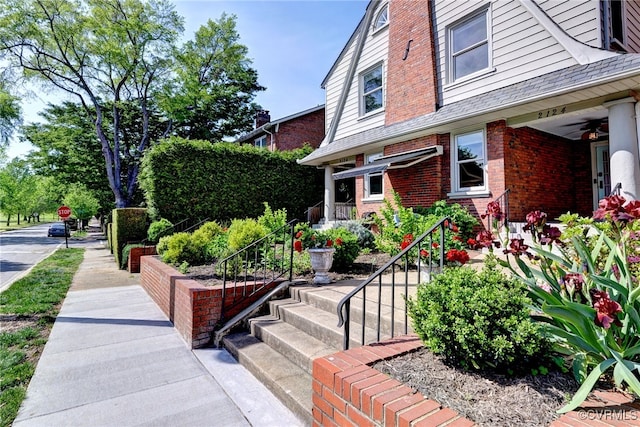 exterior space with brick siding and ceiling fan
