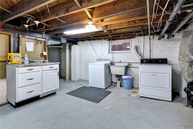basement with washer and clothes dryer and a sink