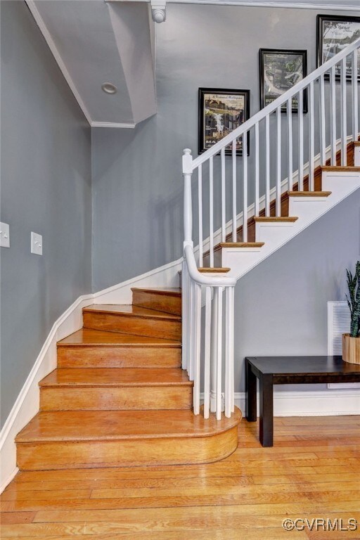 stairs with wood finished floors and baseboards