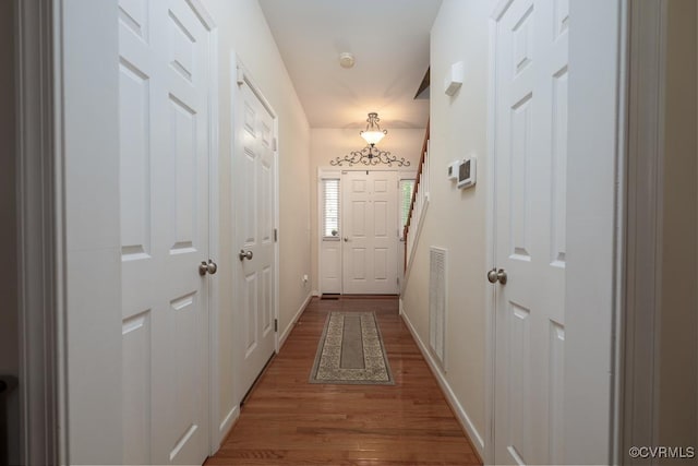 entryway with baseboards, visible vents, and wood finished floors