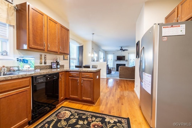kitchen with brown cabinets, light wood-style flooring, freestanding refrigerator, open floor plan, and dishwasher
