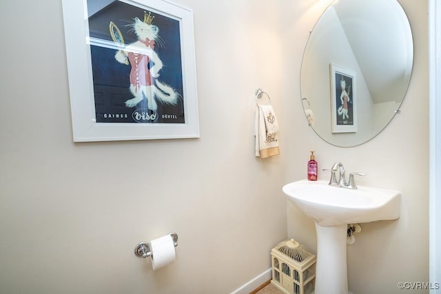 bathroom with a sink and baseboards