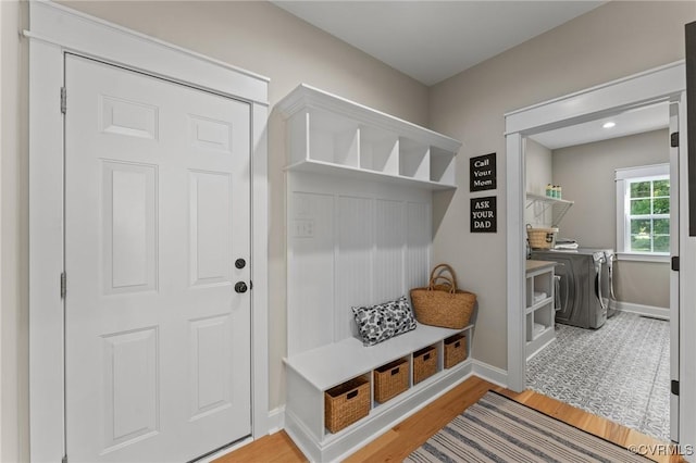 mudroom featuring wood finished floors, washing machine and clothes dryer, and baseboards