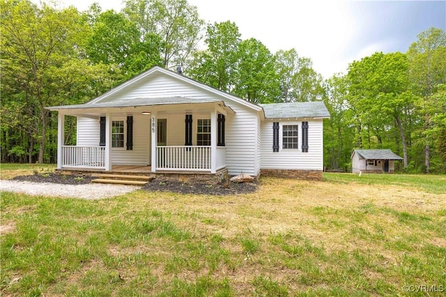 view of front of home featuring an outbuilding, a front yard, and covered porch