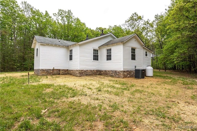 view of home's exterior featuring cooling unit and a lawn