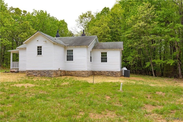 view of home's exterior with a shingled roof and a yard