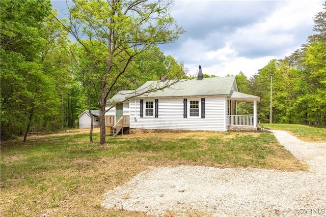 view of property exterior with driveway, a lawn, and a porch