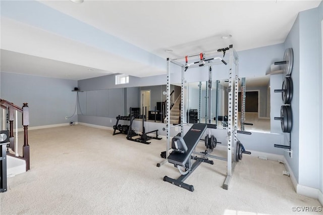 exercise area featuring baseboards and carpet flooring