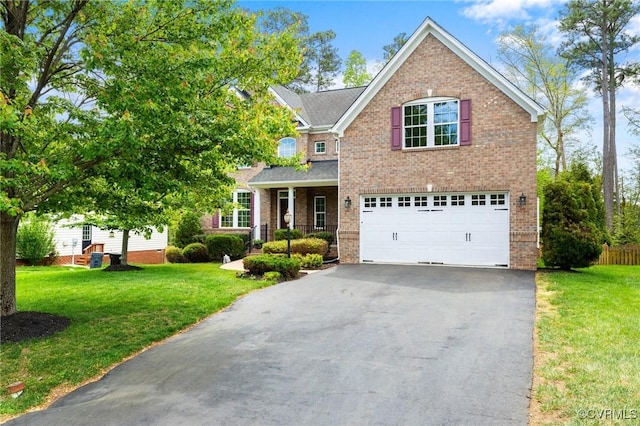 traditional home featuring a garage, brick siding, driveway, and a front yard