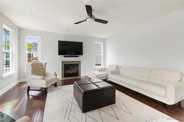 living area featuring hardwood / wood-style floors, baseboards, a fireplace with flush hearth, and recessed lighting