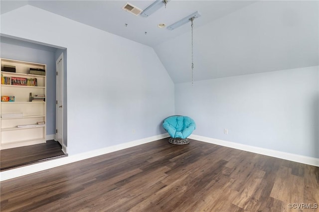 additional living space with visible vents, vaulted ceiling, wood finished floors, and baseboards