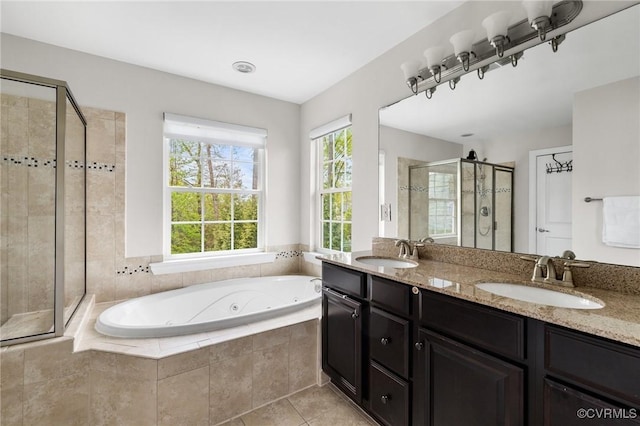 full bath featuring a stall shower, double vanity, a whirlpool tub, and a sink