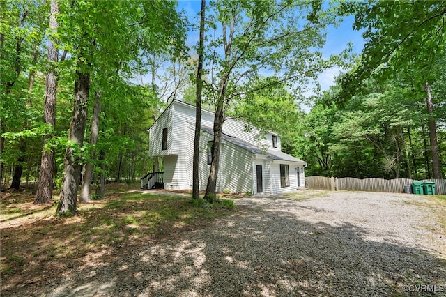exterior space featuring fence and gravel driveway