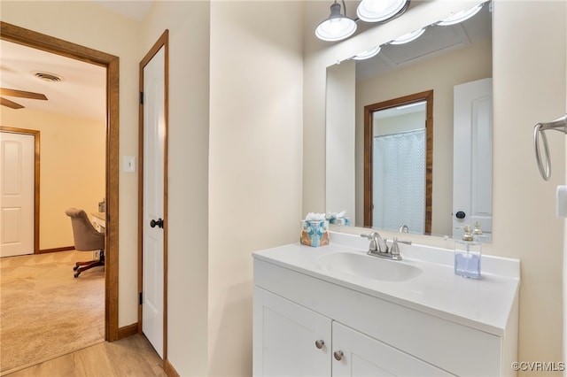 full bath featuring visible vents, baseboards, wood finished floors, and vanity