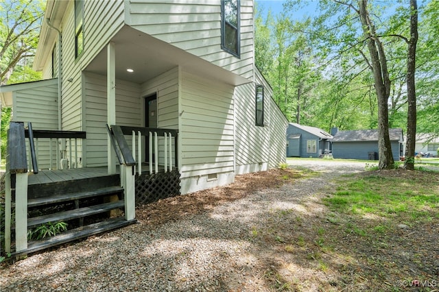 view of home's exterior with dirt driveway and crawl space