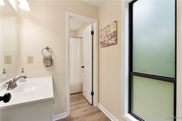 bathroom with baseboards, wood finished floors, and vanity