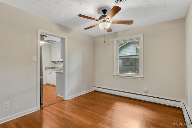 13101 Harrowgate Rd, Chester, VA 23831 - spare room featuring ceiling fan, light wood-type flooring, a baseboard heating unit, baseboards, and a textured ceiling