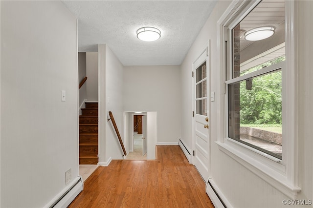 13101 Harrowgate Rd, Chester, VA 23831 - hall featuring a baseboard radiator, light wood finished floors, a textured ceiling, and stairs