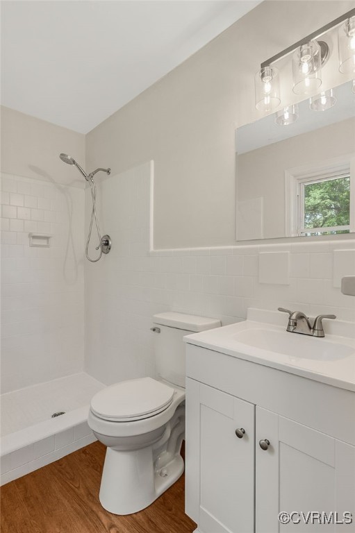 13101 Harrowgate Rd, Chester, VA 23831 - full bath with tile walls, toilet, tiled shower, vanity, and wood finished floors