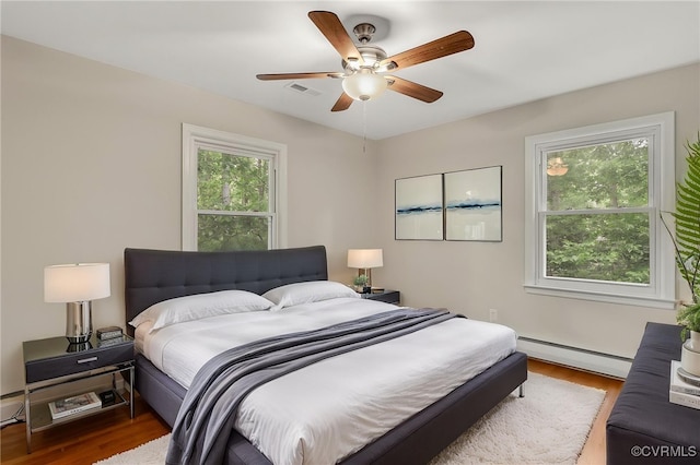 13101 Harrowgate Rd, Chester, VA 23831 - bedroom featuring baseboard heating, wood finished floors, and a ceiling fan
