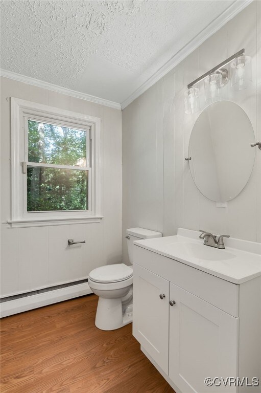 13101 Harrowgate Rd, Chester, VA 23831 - bathroom with baseboard heating, ornamental molding, a textured ceiling, toilet, and vanity