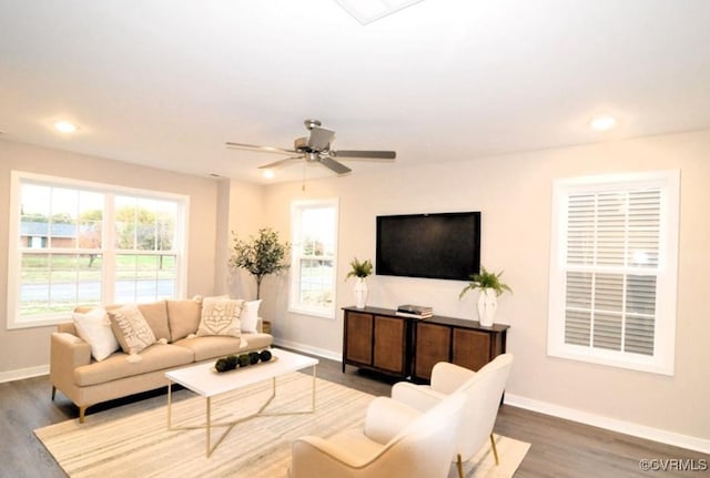 living area featuring recessed lighting, a healthy amount of sunlight, wood finished floors, and baseboards
