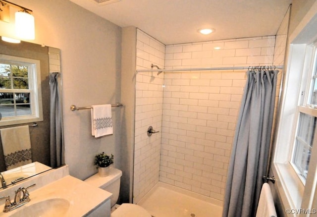 full bathroom featuring recessed lighting, tiled shower, toilet, and vanity