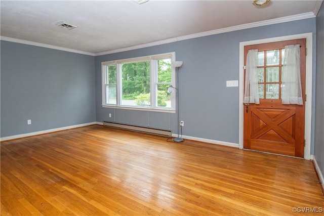 spare room with baseboard heating, baseboards, light wood-style flooring, and crown molding