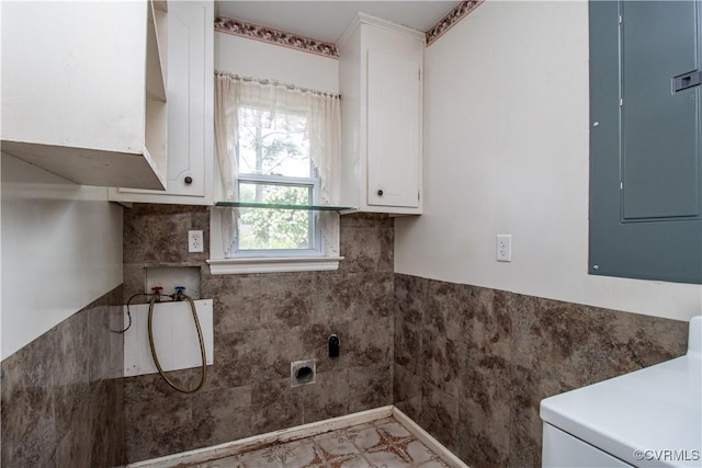 washroom with electric panel, cabinet space, and washer / clothes dryer