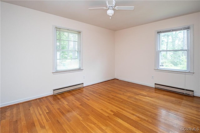 empty room with baseboard heating, healthy amount of natural light, and light wood-style floors