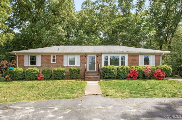 single story home with a front yard and brick siding