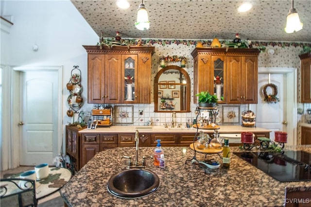5301 Middle Rd, Prince George, VA 23875 - kitchen featuring decorative light fixtures, black electric stovetop, tasteful backsplash, wallpapered walls, and glass insert cabinets