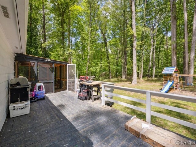 wooden terrace with a sunroom and a playground