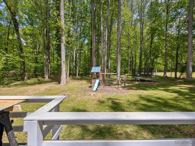view of yard featuring a trampoline and playground community