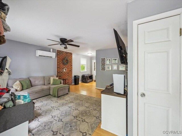 living area featuring wood finished floors, a ceiling fan, and a wall mounted AC