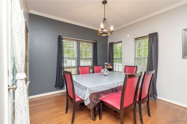dining space with crown molding, an inviting chandelier, wood finished floors, and baseboards