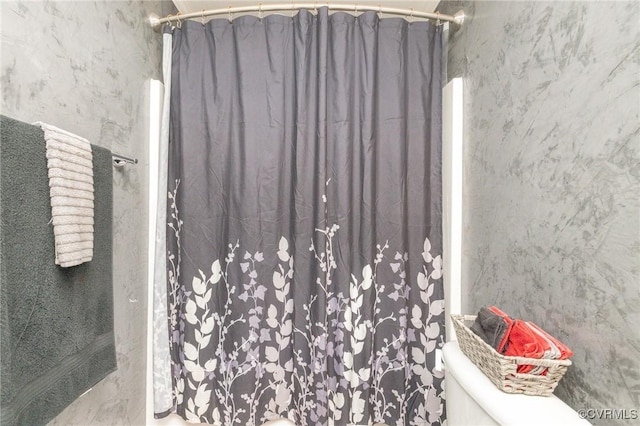 bathroom with curtained shower and toilet