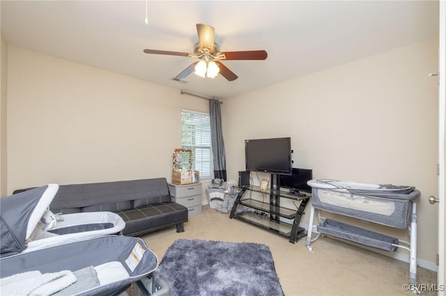 living room with a ceiling fan, visible vents, and light colored carpet