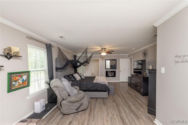 bedroom featuring visible vents, wood finished floors, ornamental molding, and baseboards