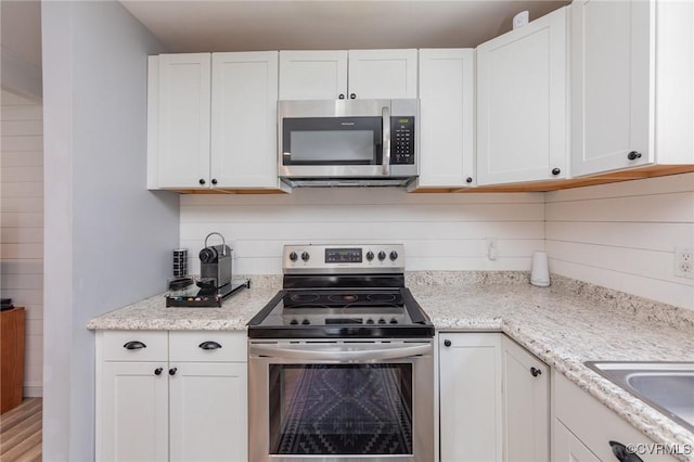 15131 Burruss Ln, Ruther Glen, VA 22546 - kitchen with stainless steel appliances, white cabinetry, and light stone countertops