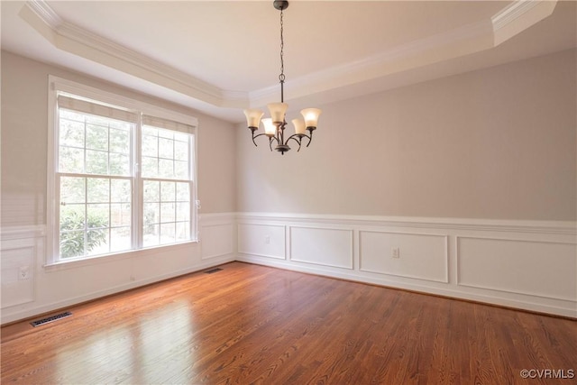 spare room featuring a tray ceiling, crown molding, a wealth of natural light, and visible vents