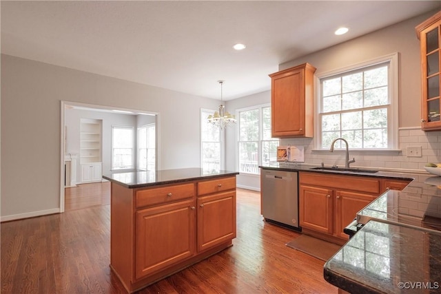 kitchen with glass insert cabinets, dishwasher, an inviting chandelier, a sink, and backsplash